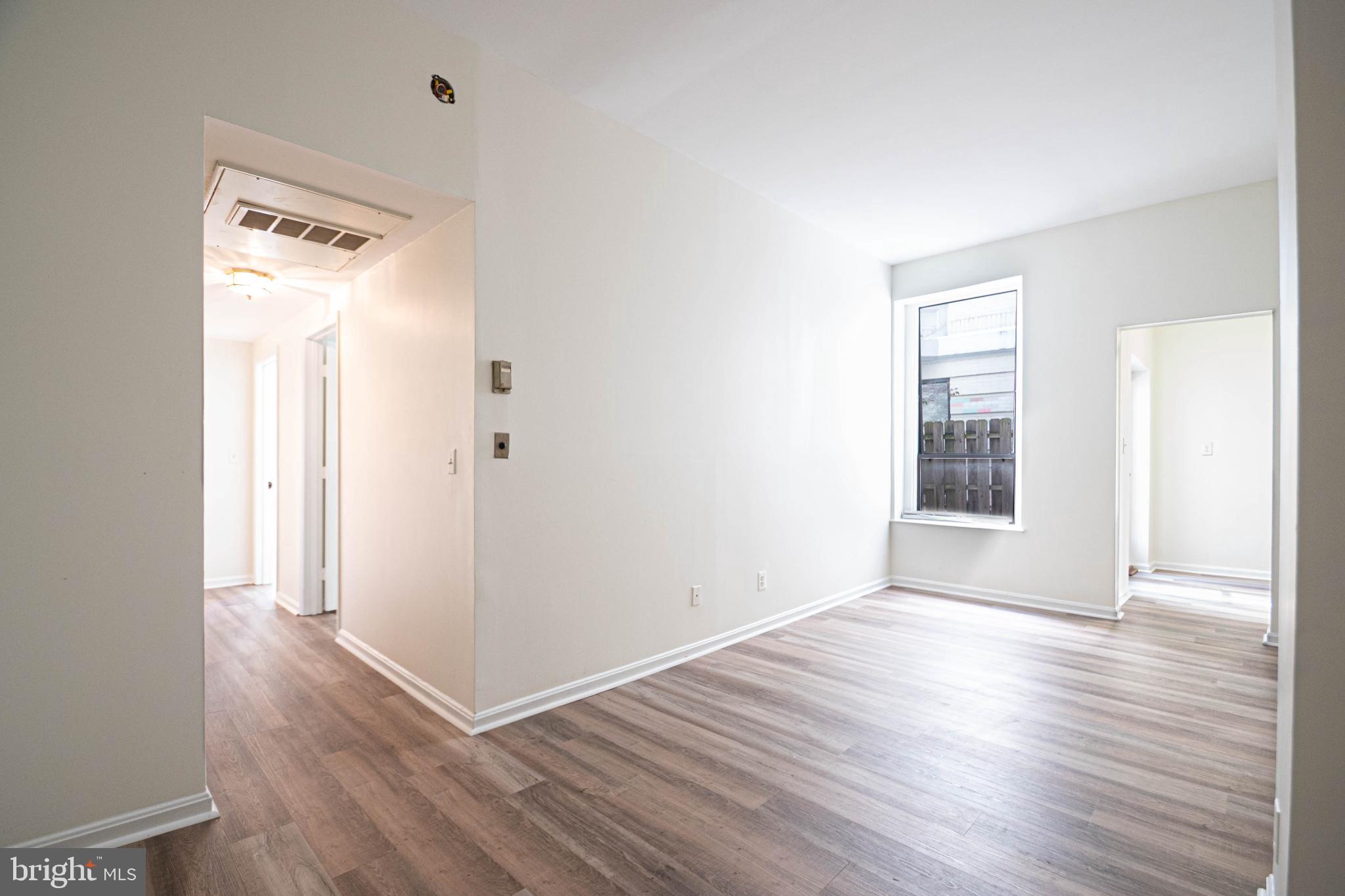1669 Columbia Road Northwest, Unit 109 Washington, DC 20009 - Photo 12 of 35 an empty room with wooden floor and windows