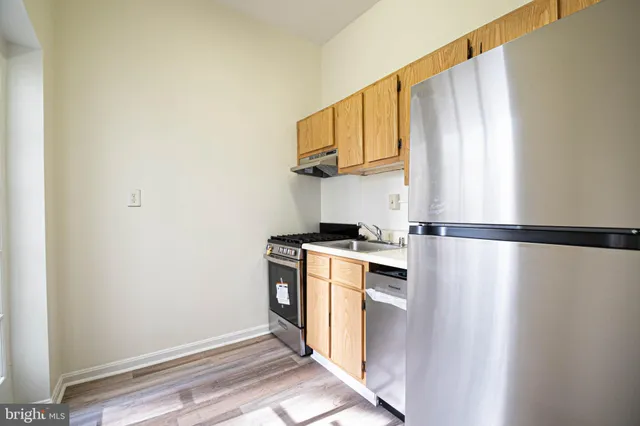 a kitchen with stainless steel appliances a refrigerator and a stove top oven