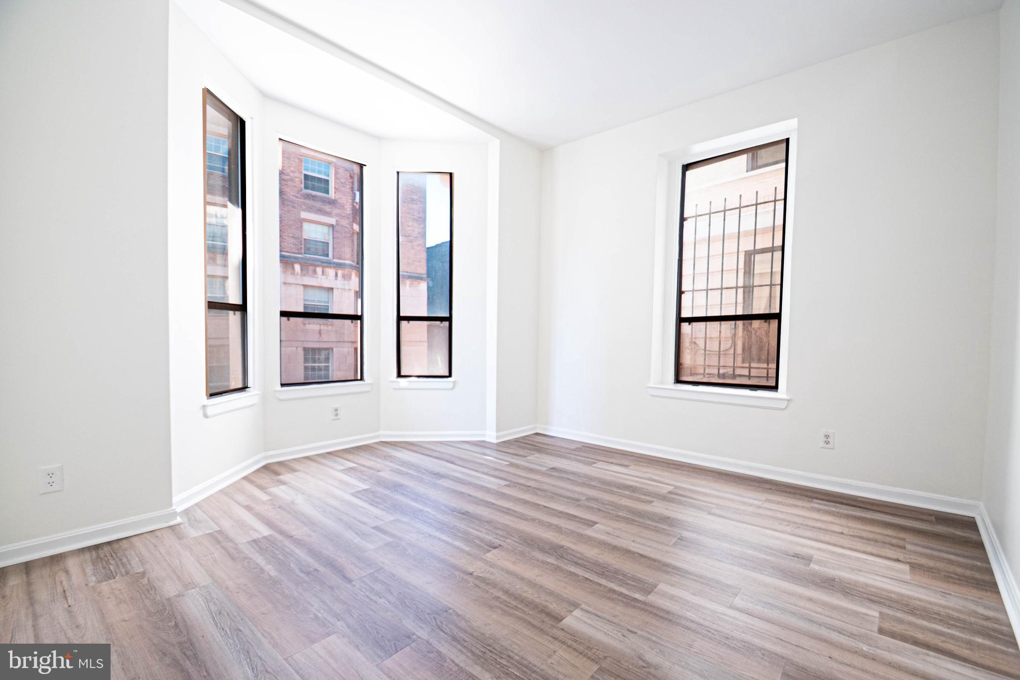 1669 Columbia Road Northwest, Unit 109 Washington, DC 20009 - Photo 23 of 35 an empty room with wooden floor and windows