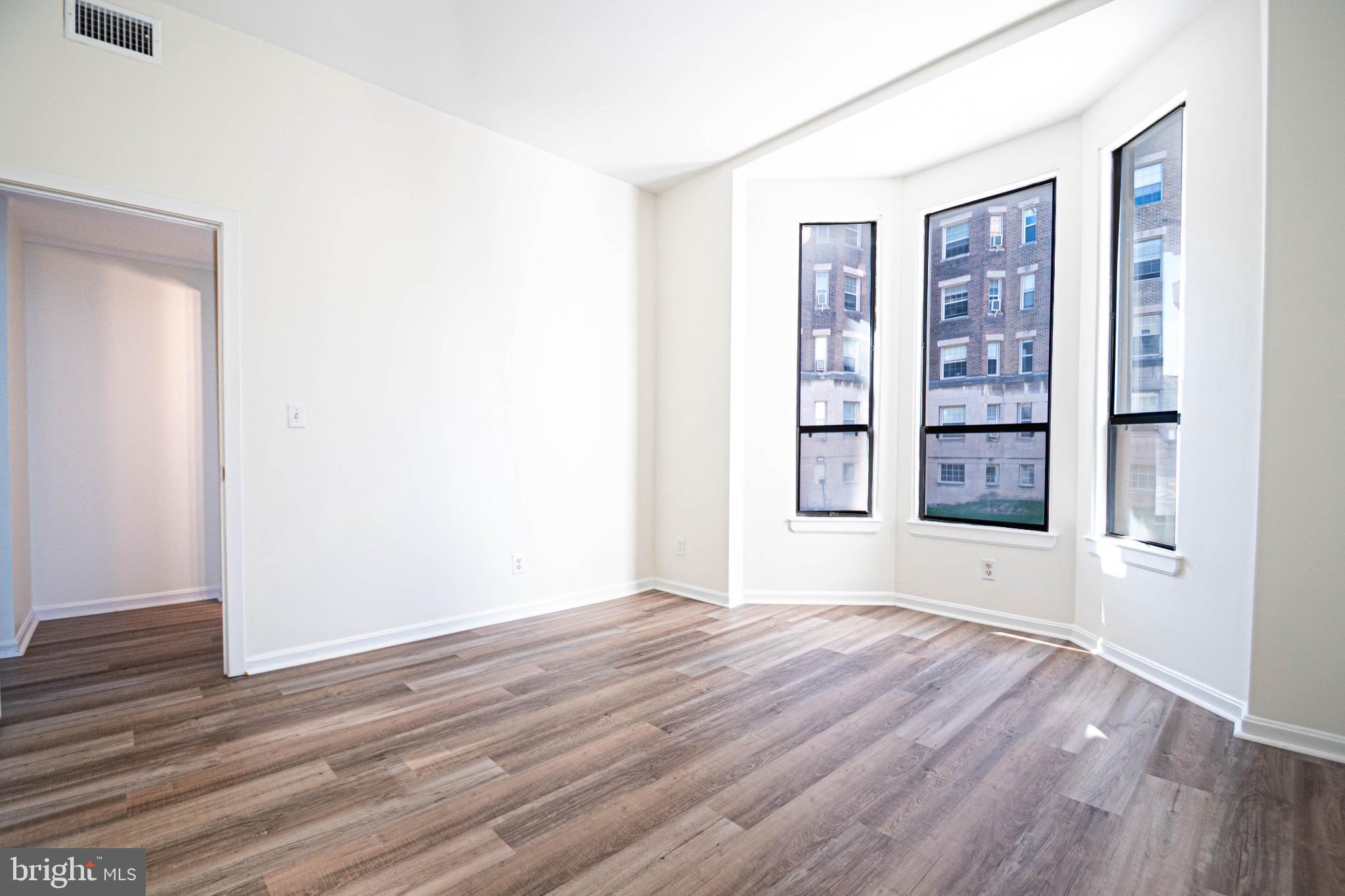 1669 Columbia Road Northwest, Unit 109 Washington, DC 20009 - Photo 26 of 35 a view of an empty room with window and wooden floor