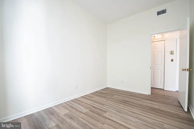a view of an empty room with wooden floor