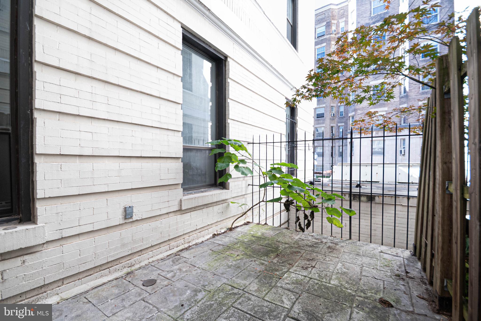 1669 Columbia Road Northwest, Unit 109 Washington, DC 20009 - Photo 32 of 35 a view of a porch with a table and chairs and wooden fence
