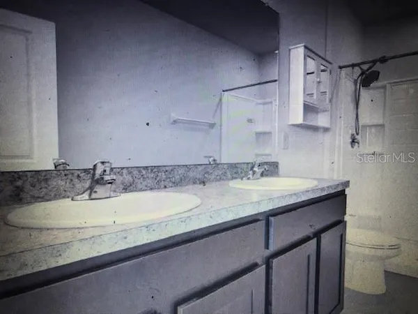 a bathroom with a granite countertop sink a toilet and a mirror