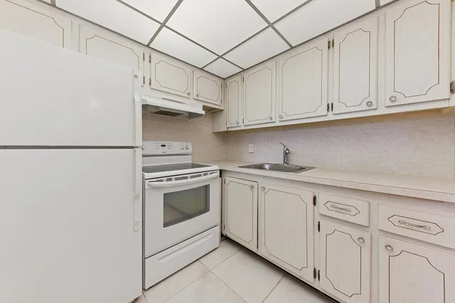 a kitchen with white cabinets and white appliances