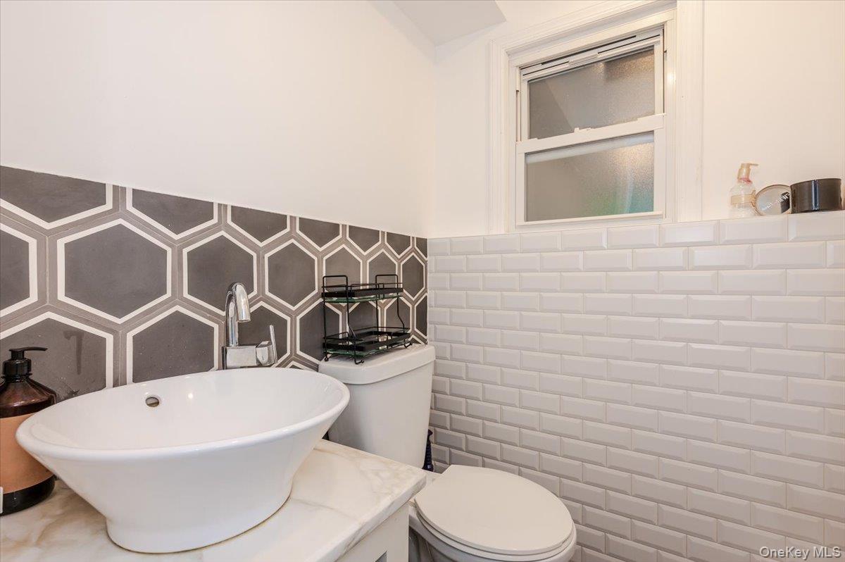 26 Redbrook Road Great Neck, NY 11024 - Photo 14 of 19 a white toilet sitting next to a bathroom sink