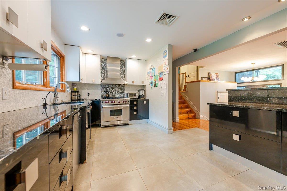 26 Redbrook Road Great Neck, NY 11024 - Photo 6 of 19 a kitchen with stainless steel appliances kitchen island granite countertop a refrigerator a stove and a sink with cabinets