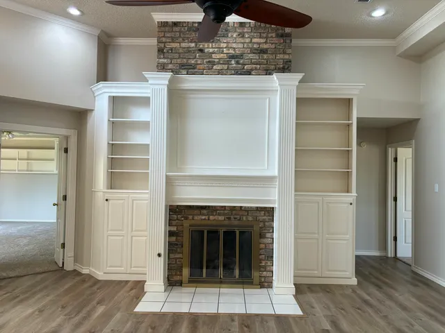 an empty room that has a large mirror and a ceiling fan