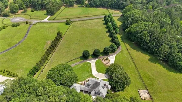 an aerial view of a house with a yard and lake view