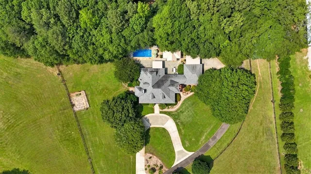 an aerial view of a house with a yard and lake view