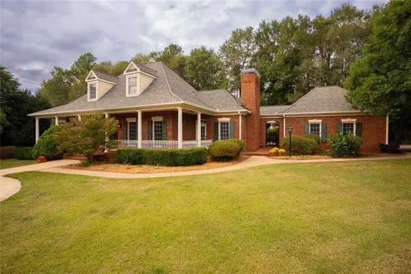 a kitchen with stainless steel appliances granite countertop a stove top oven a sink a dining table and chairs