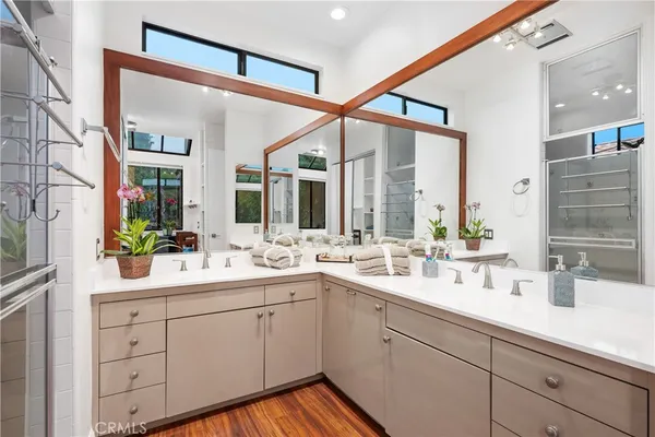 a bathroom with a double vanity sink mirror and bathtub