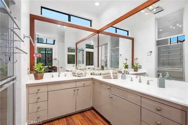 a bathroom with a double vanity sink mirror and bathtub