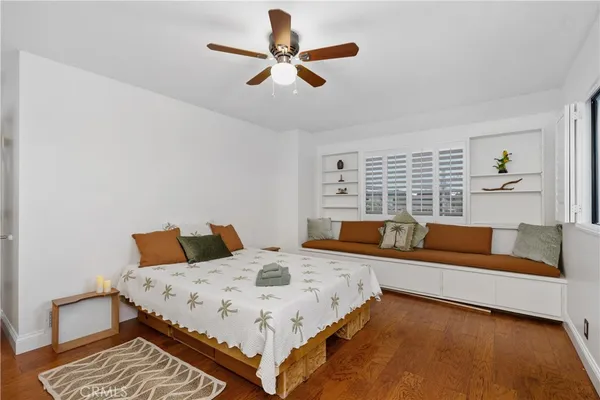 a spacious bedroom with a bed and wooden floor