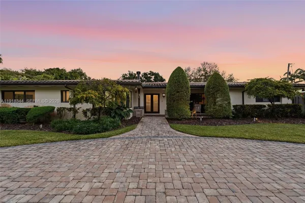 a view of a house with a yard and potted plants