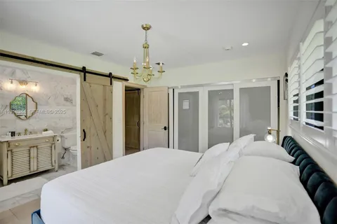a bedroom with a large bed and a chandelier