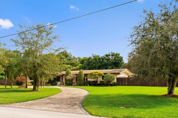 a front view of a house with a yard and trees