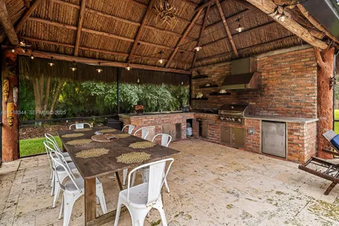 a view of a backyard with table and chairs a barbeque with wooden floor