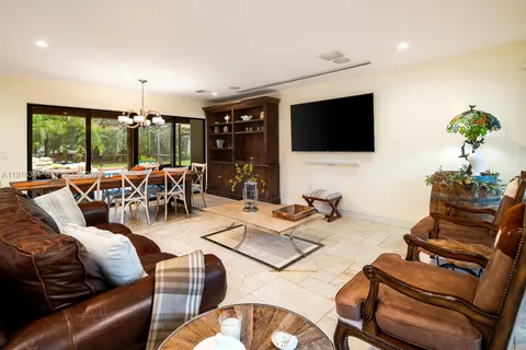 a living room with furniture a flat screen tv and a large window