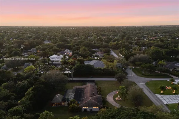 an aerial view of residential houses with outdoor space and trees