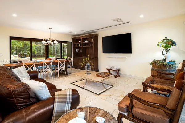 a living room with furniture a flat screen tv and a large window
