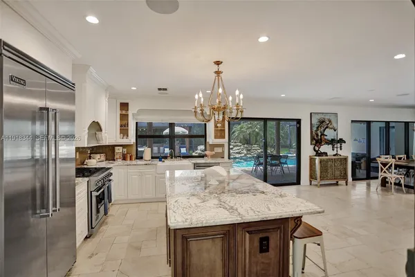 a kitchen with stainless steel appliances granite countertop a sink refrigerator and cabinets