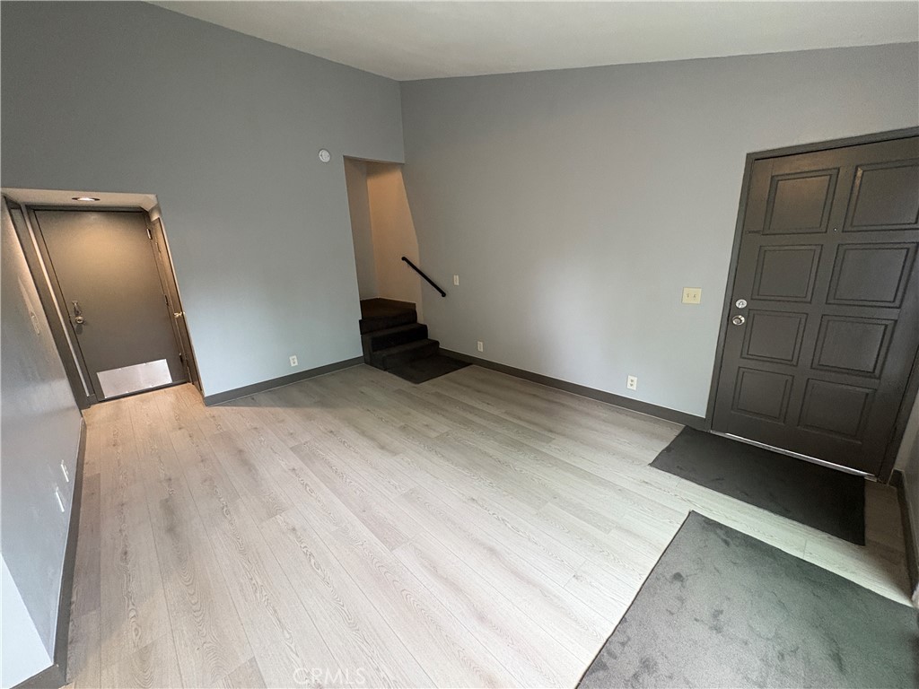2826 Cogswell Road, Unit A #M El Monte, CA 91732 - Photo 11 of 55 an empty room with wooden floor and mirror
