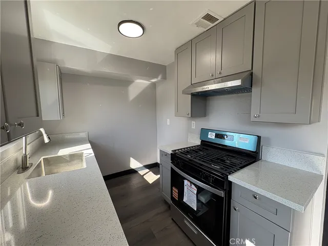 a kitchen with a sink a stove and cabinets