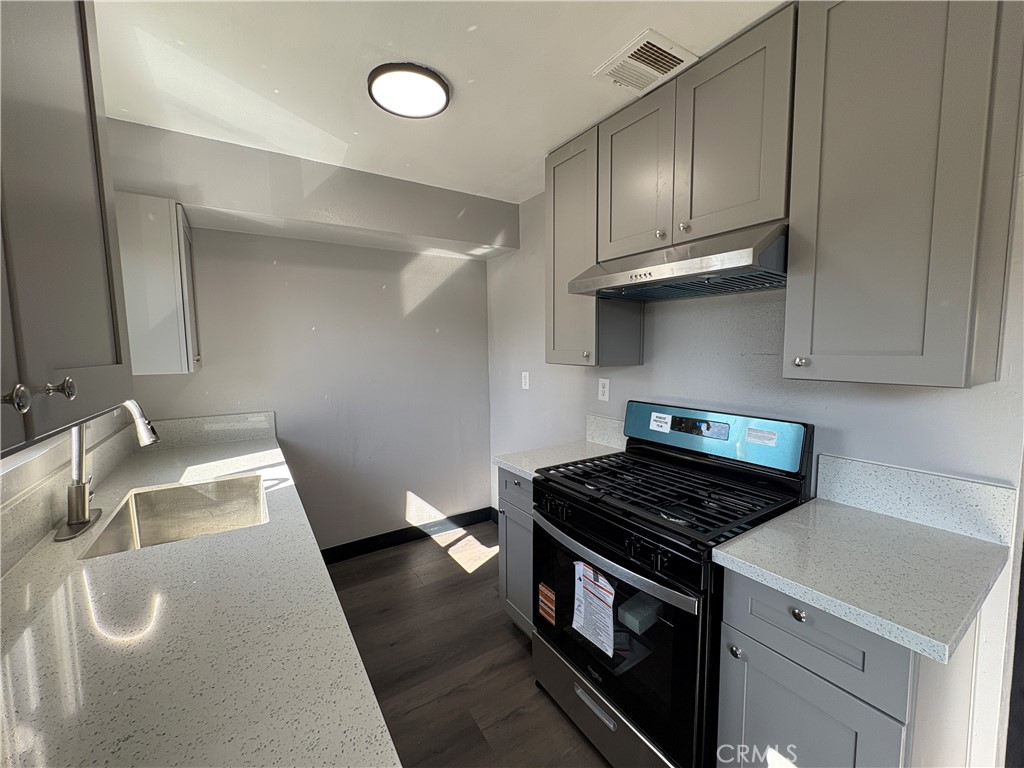 2826 Cogswell Road, Unit A #M El Monte, CA 91732 - Photo 31 of 55 a kitchen with granite countertop a sink a stove and cabinets