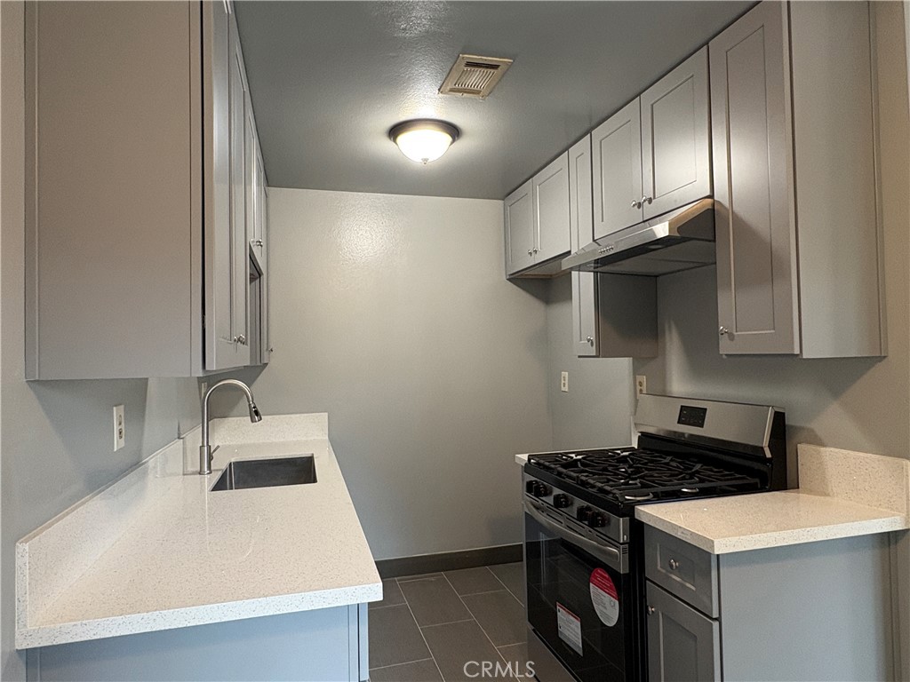 2826 Cogswell Road, Unit A #M El Monte, CA 91732 - Photo 7 of 55 a kitchen with granite countertop a sink a stove and refrigerator