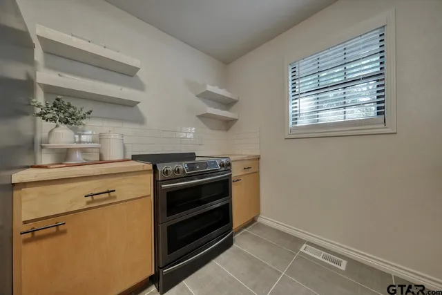 a kitchen with a stove and white cabinets