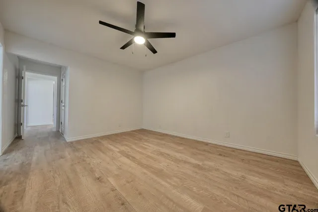 a bathroom with a granite countertop sink a toilet a mirror and window