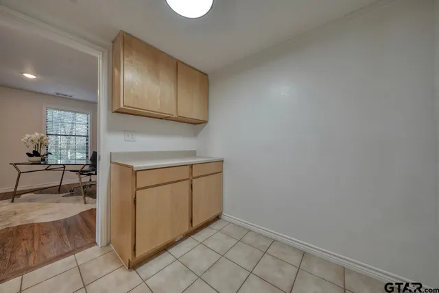 an empty room with wooden floor ceiling fan and windows