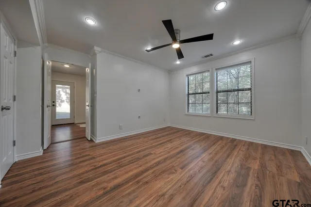 a view of empty room with wooden floor and window