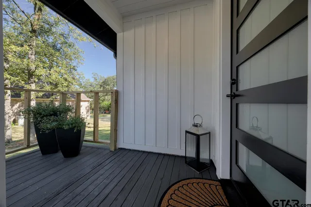 a view of a hallway with wooden floor and a potted plant