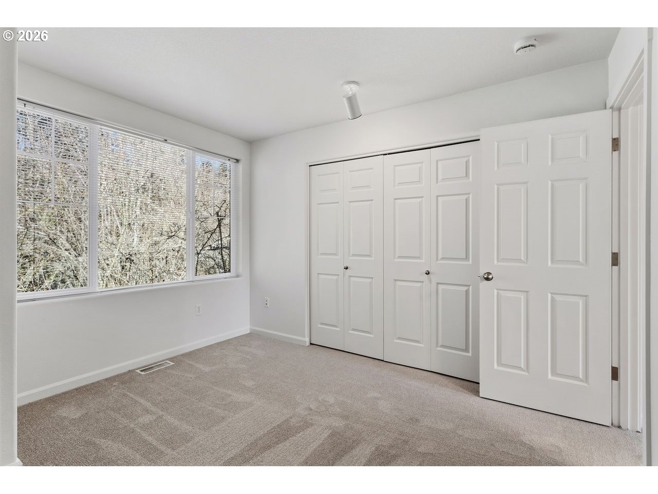 15450 Southwest Sparrow Loop, Unit 102 Beaverton, OR 97007 - Photo 17 of 27 a view of an empty room with window and closet area