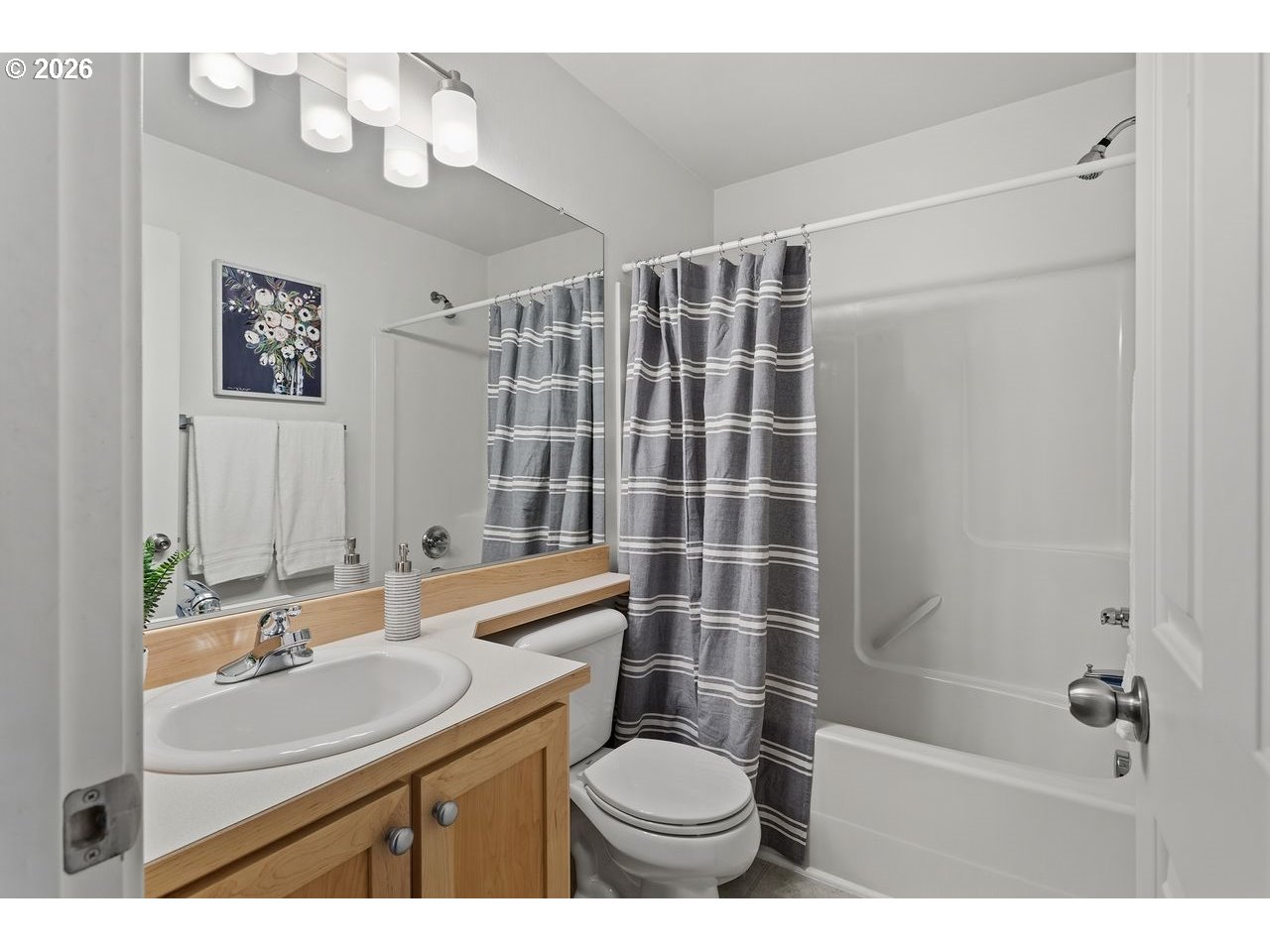 15450 Southwest Sparrow Loop, Unit 102 Beaverton, OR 97007 - Photo 21 of 27 a bathroom with a sink toilet a mirror and shower