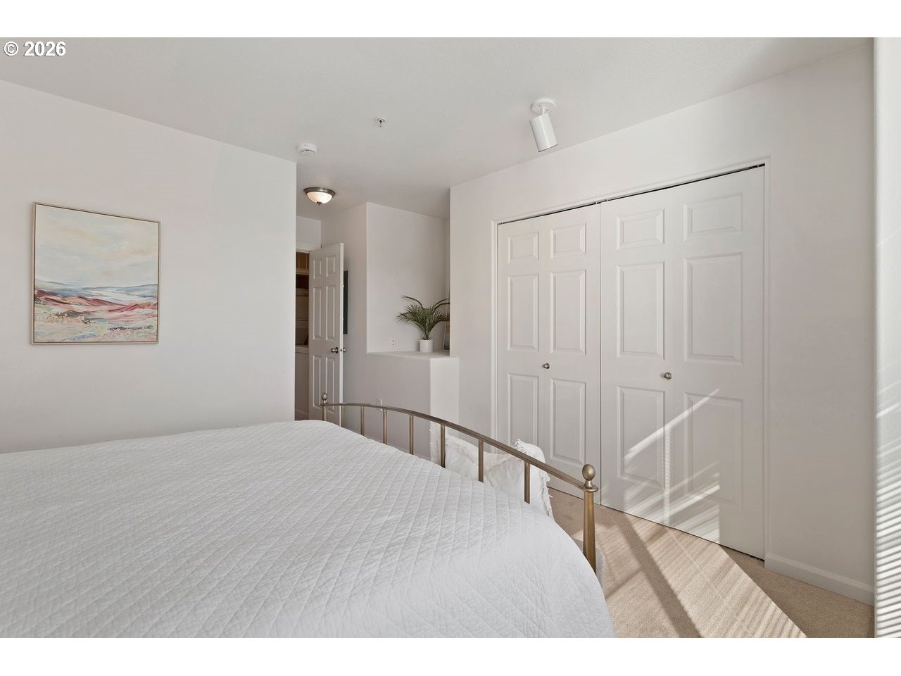 15450 Southwest Sparrow Loop, Unit 102 Beaverton, OR 97007 - Photo 22 of 27 a bedroom with a bed and a chandelier