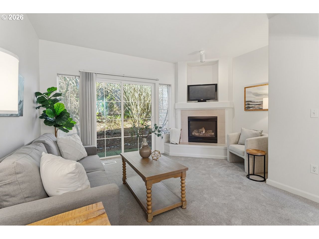 15450 Southwest Sparrow Loop, Unit 102 Beaverton, OR 97007 - Photo 3 of 27 a living room with furniture a flat screen tv and a fireplace
