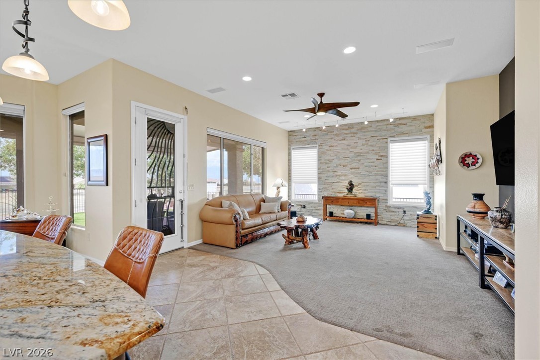 1823 Baton Rouge Street Henderson, NV 89052 - Photo 58 of 60 An open floorplan seamlessly connects the stone-detailed living space to the tile-floored dining area.