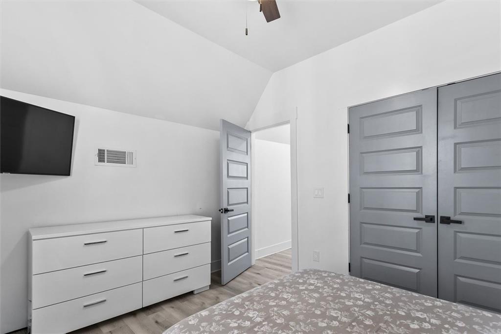 658 Rockbridge Road Northwest Lilburn, GA 30047 - Photo 7 of 61 a bedroom with a bed and a television in it