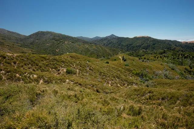 a view of a large mountain with mountains in the background