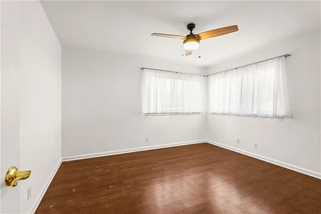 an empty room with window and ceiling fan