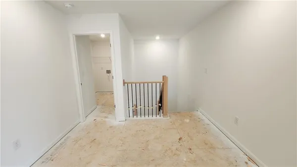 an empty room with windows and ceiling fan
