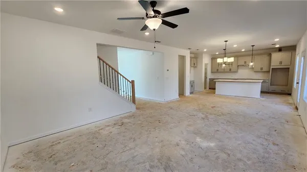 a view of an empty room and kitchen view