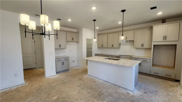 a kitchen with kitchen island granite countertop a sink a center island and stainless steel appliances