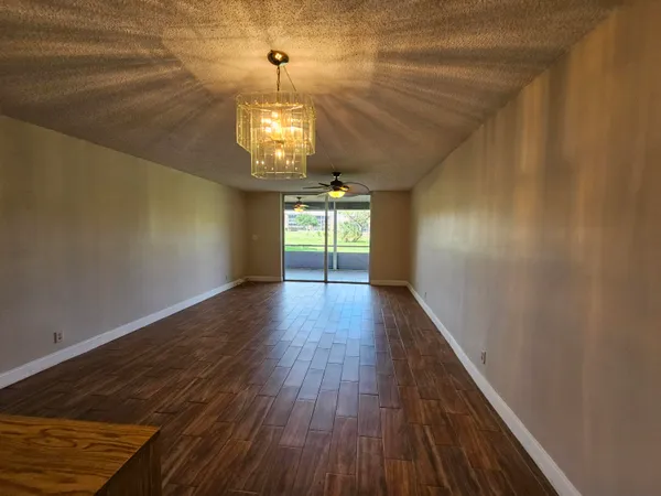 a view of a room with wooden floor chandelier and entryway