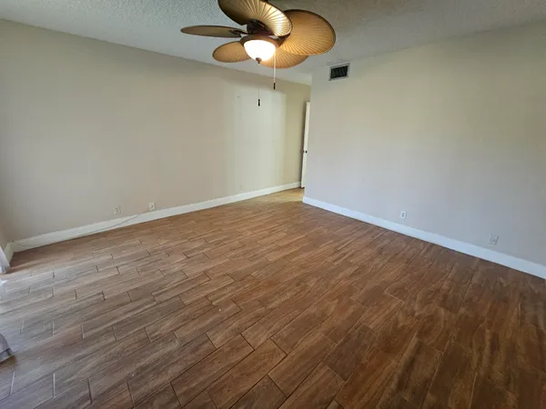 a view of an empty room with a chandelier fan