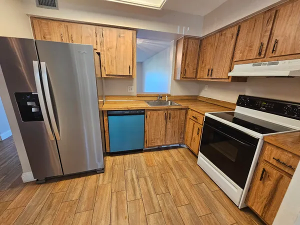 a kitchen with stainless steel appliances granite countertop a refrigerator stove and sink