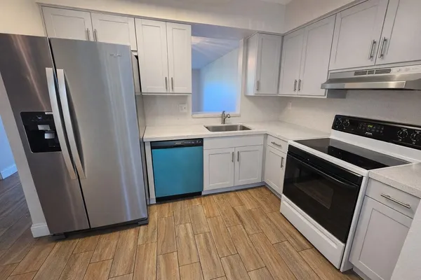 a kitchen with a sink a refrigerator and cabinets