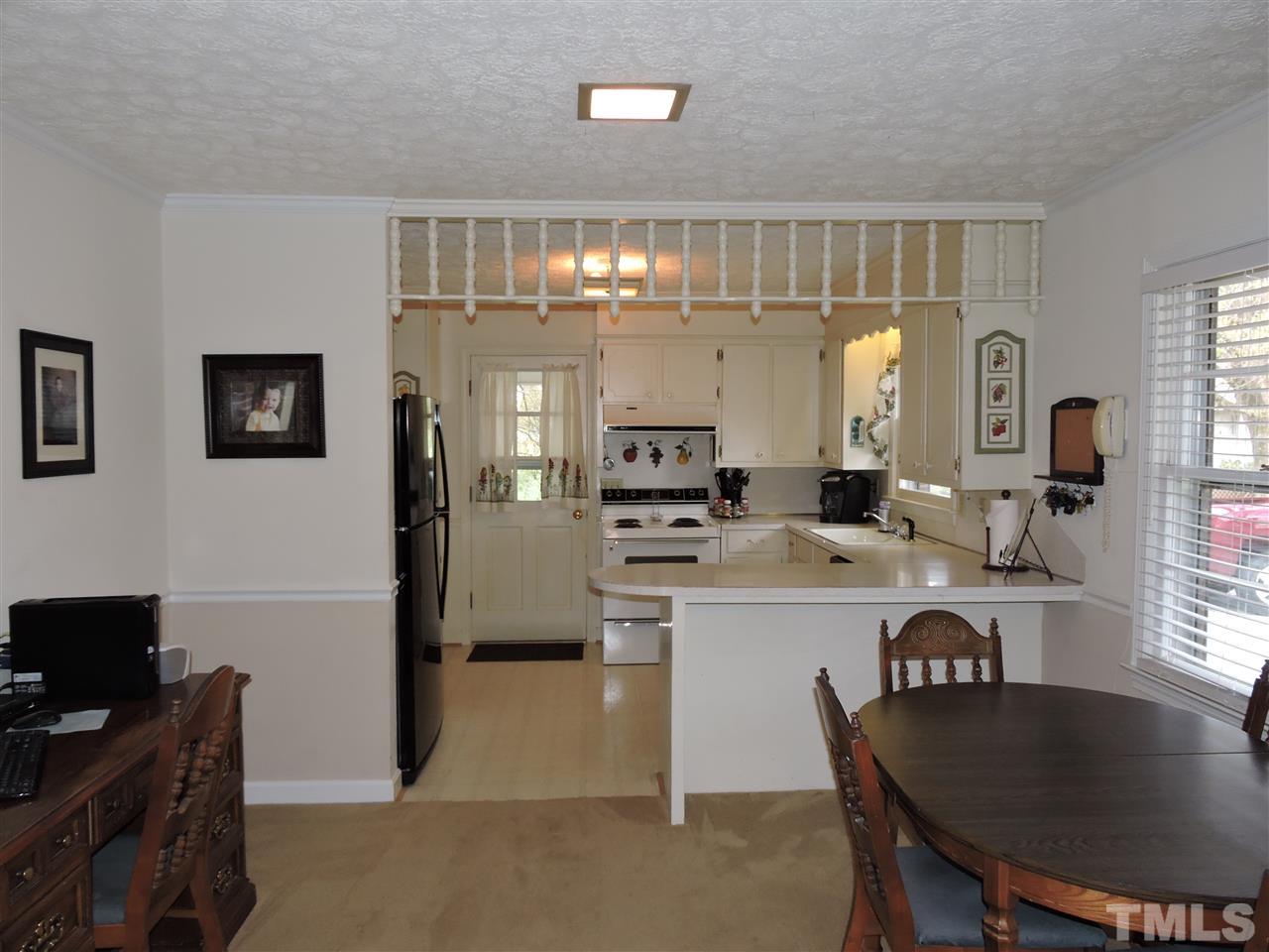 1104 Ridge Road Roxboro, NC 27573 - Photo 5 of 15 a kitchen with kitchen island a dining table chairs cabinets and stainless steel appliances